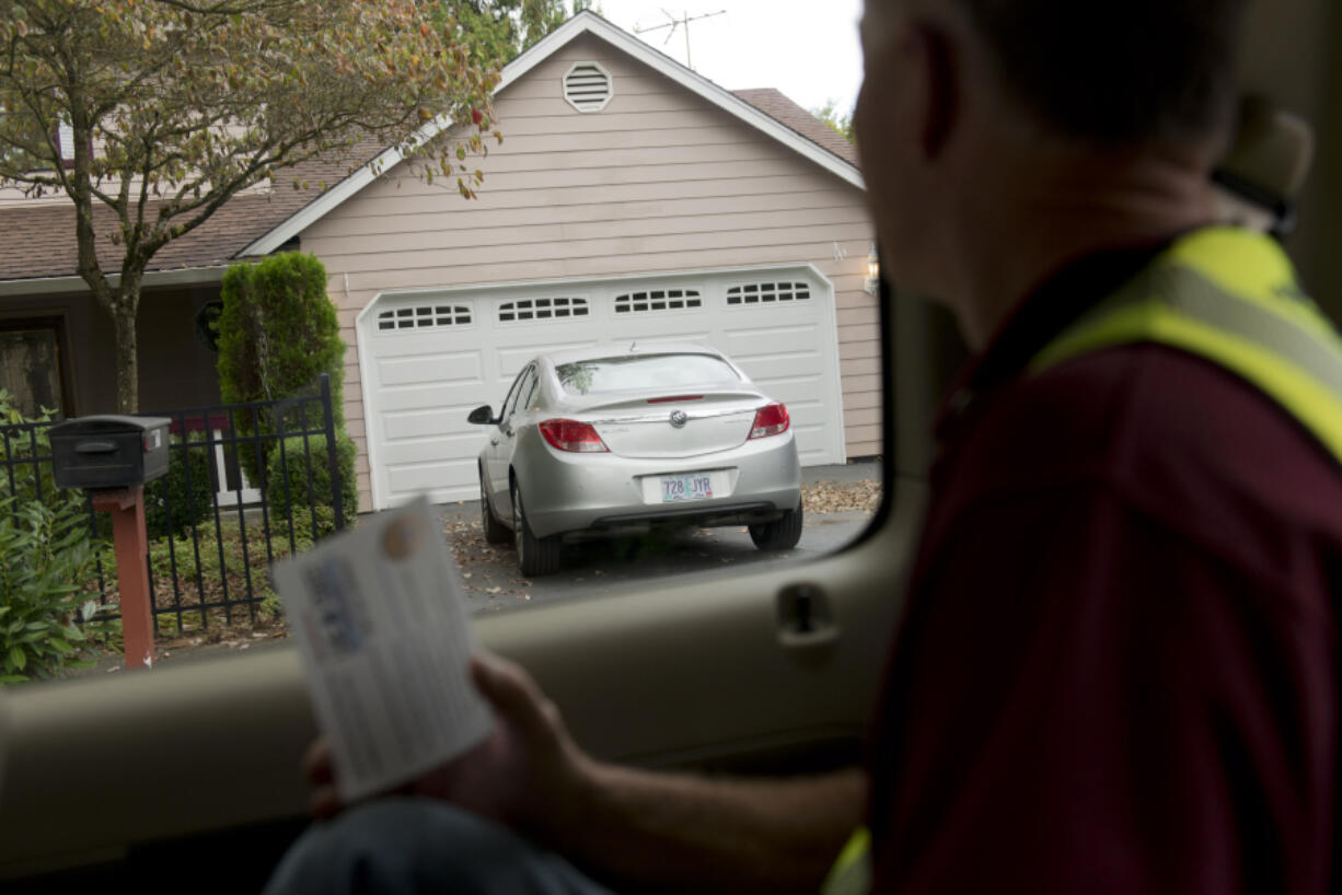 Neighbors On Watch volunteer Scott Abels reads off an Oregon license plate to another volunteer taking notes in the Landover-Sharmel neighborhood. Vancouver police are starting a program to encourage voluntary license compliance, and NOW volunteers are taking to the streets of Vancouver to inventory out-of-state license plates in neighborhoods.