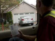 Neighbors On Watch volunteer Scott Abels reads off an Oregon license plate to another volunteer taking notes in the Landover-Sharmel neighborhood. Vancouver police are starting a program to encourage voluntary license compliance, and NOW volunteers are taking to the streets of Vancouver to inventory out-of-state license plates in neighborhoods.