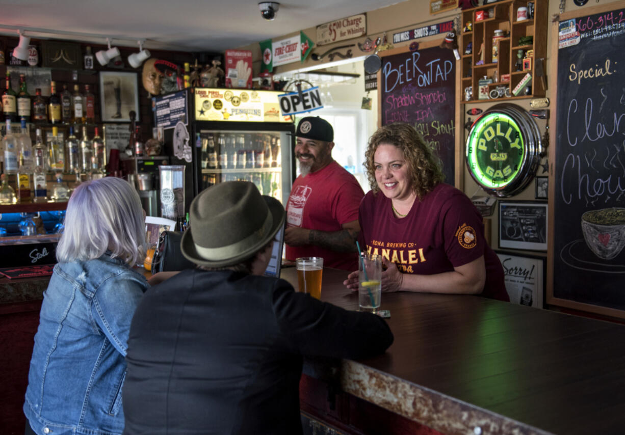 Bill and Elizabeth Walters chat with customers Tasha Wood and Amy Graeff, both of Vancouver, at The Rusty Chain in Vancouver’s Carter Park neighborhood on Friday afternoon. Wood and Graeff live nearby and say the bar and grill is their favorite spot.