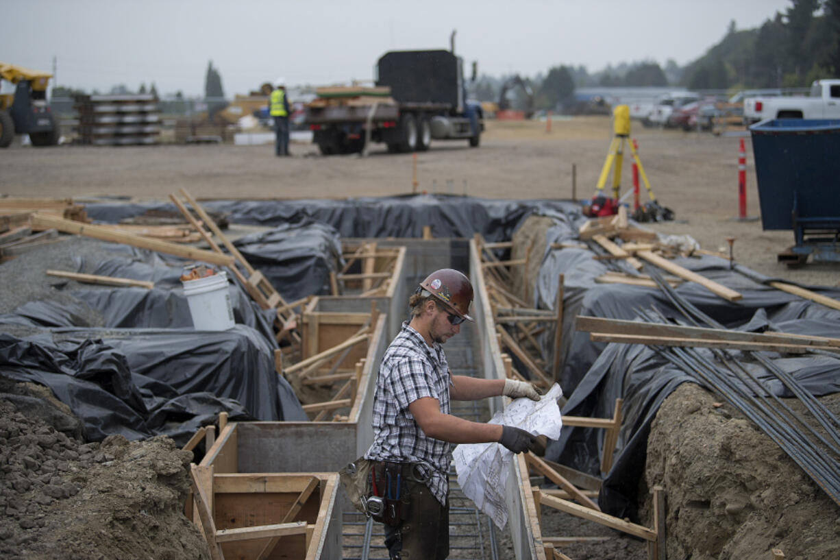 Mathew Beraldo, working for a subcontractor for Killian Pacific, looks over plans while working with colleagues to build a new office park on Columbia House Boulevard. The first phase is a 45,000-square-foot office for a tenant yet to be revealed.