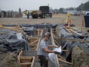 Mathew Beraldo, working for a subcontractor for Killian Pacific, looks over plans while working with colleagues to build a new office park on Columbia House Boulevard. The first phase is a 45,000-square-foot office for a tenant yet to be revealed.