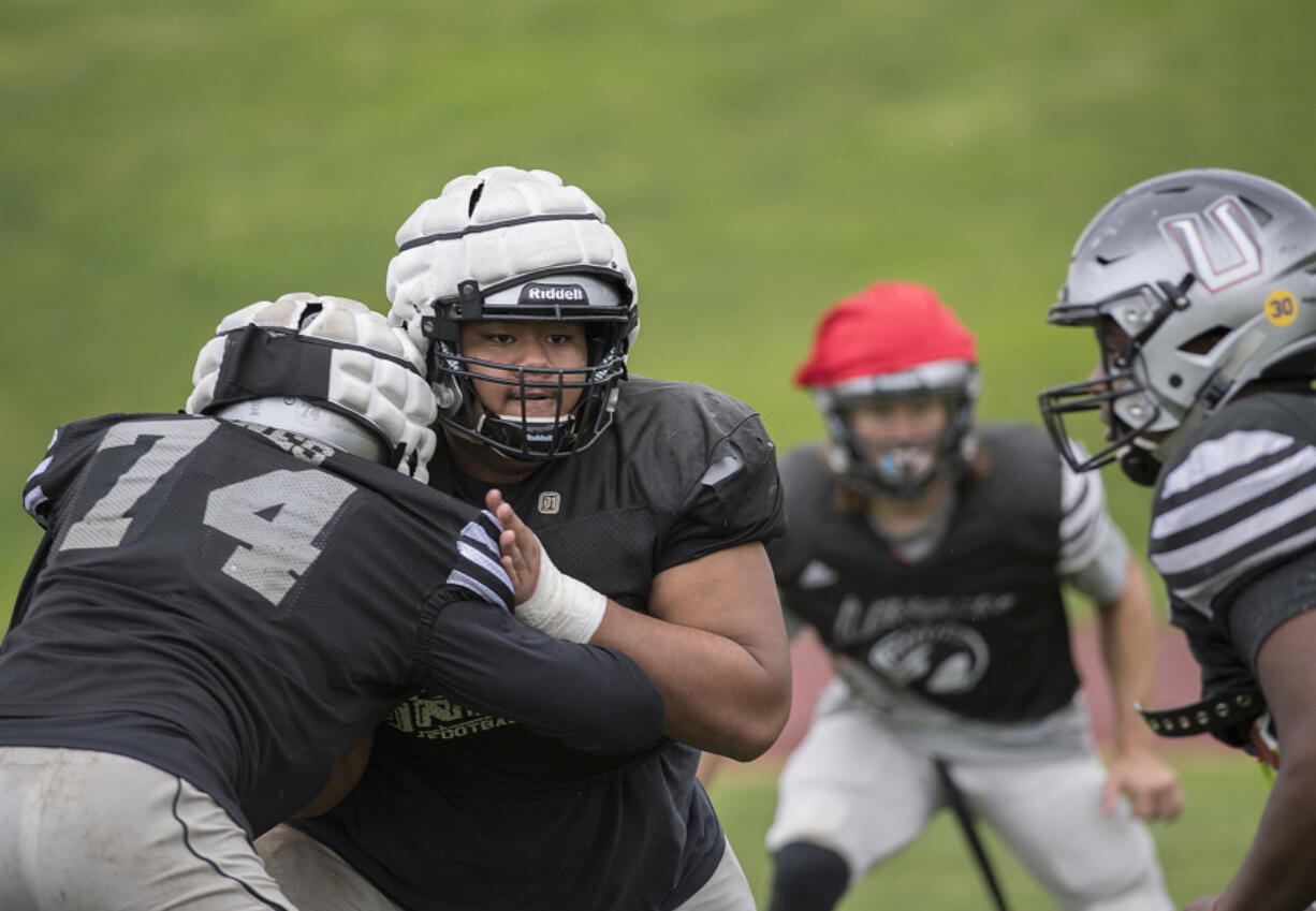 Union’s Sausau Faalevao, second from right, takes on teammates during practice Tuesday afternoon, Oct. 10, 2017.