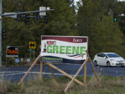 A motorist passes campaign signs for Port of Vancouver District 1 candidates Kris Green, foreground, and Don Orange at the intersection of Northwest 78th Street and Northwest Lakeshore Avenue on Wednesday morning.