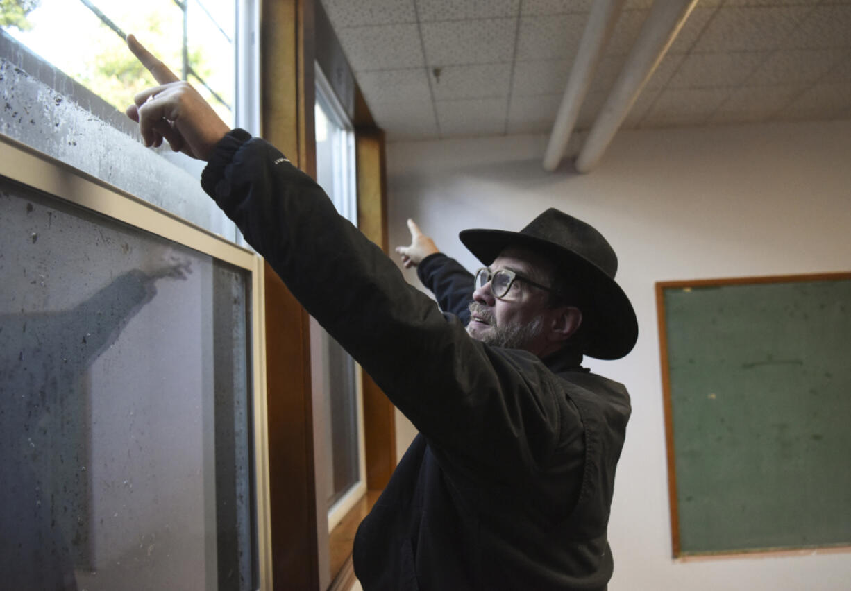 The Rev. Jaime Case points to a waterline on three windows in the basement of St. Luke’s Episcopal Church in west Vancouver. Heavy rains on Thursday caused flooding in a large part of the church’s basement.