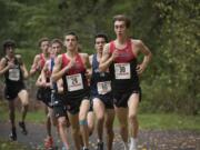 Camas’ Jackson Lyne (29), left, Skyview’s Bruce Erickson (60) and Camas’ Daniel Maton (30) race down trail at Lewisville Park in Battle Ground, Wednesday October 18, 2017, during the boy’s 4A district cross country championships.