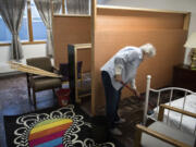 Mary Ellen Sandberg cleans out a room in the basement of St. Luke’s Episcopal Church, which was being prepped Thursday to become a shelter for homeless women.