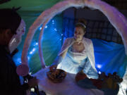 Vancouver’s Nicole Jensen, dressed as Cinderella, hands out candy at the annual trick-or-treating set up at the Department of Social and Health Services offices in Vancouver on Monday. The office split into sections, with staff decorating and dressing in costume, in themes ranging from “Moana,” “Batman” and “Trolls” dolls.