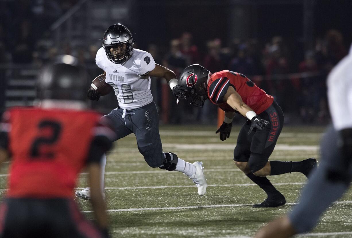 Union's Joseph Siofele (26) holds off Camas' Will Schultz (37) during Friday night's rivalry game at Doc Harris Stadium in Camas on Oct. 27, 2017.