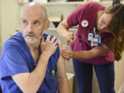 Joel Justus, a central sterile technician, receives a flu shot from Lindsey Wreden.