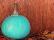 A teal pumpkin on a porch signals allergy-friendly or non-food treats, part of the Teal Pumpkin Project.