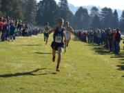 Kyle Radosevich of Ridgefield kicks to the finish line to win the 2A district cross country title on Saturday, Oct. 28, 2017, at Lewis River Golf Course in Woodland.