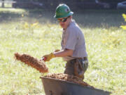 Volunteer Ben Johnston scoops wood chips for an all-season pathway at Raymond E. Shaffer Park as part of Make a Difference Day.