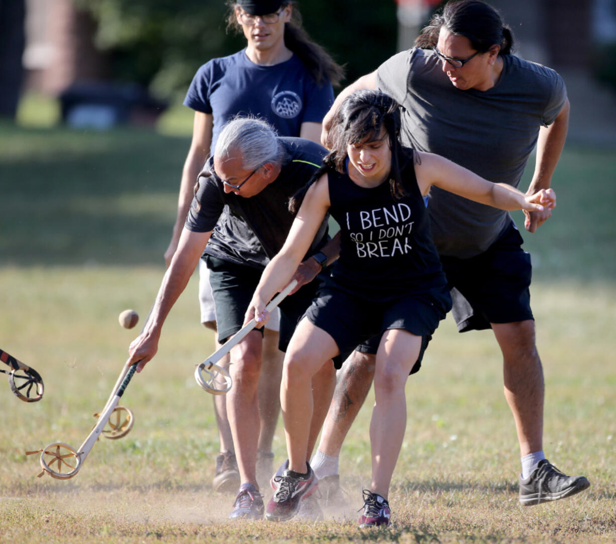 Sasha Houston Brown, center, battles for the ball during an evening of the Creator’s game, most closely resembling lacrosse, at Corcoran Park in Minneapolis on Sept. 17. “It brings out people who would not normally come out for sports,” said Houston Brown, a leading voice for the revival of lacrosse among Indians. “We know each other’s kids and each other’s families.