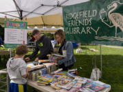 The Boyd family of Ridgefield — 9-year-old Everett, left, dad Brian, center, and mom Sara — browse at the Friends of Ridgefield Community Library sale during BirdFest at Overlook Park.