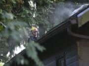 A firefighter works on a roof of a home that caught fire in the Hough Neighborhood, Monday afternoon, October 9, 2017.