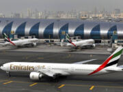 FILE - In this Wednesday, March 22, 2017 file photo, an Emirates plane taxis to a gate at Dubai International Airport at Dubai International Airport in Dubai, United Arab Emirates. Long-haul carrier Emirates says it is starting new screening procedures for U.S.-bound passengers following it receiving "new security guidelines" from American authorities.