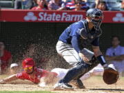 Seattle Mariners catcher Mike Marjama, right, waits for the throw as Los Angeles Angels’ Shane Robinson scores on Sunday.