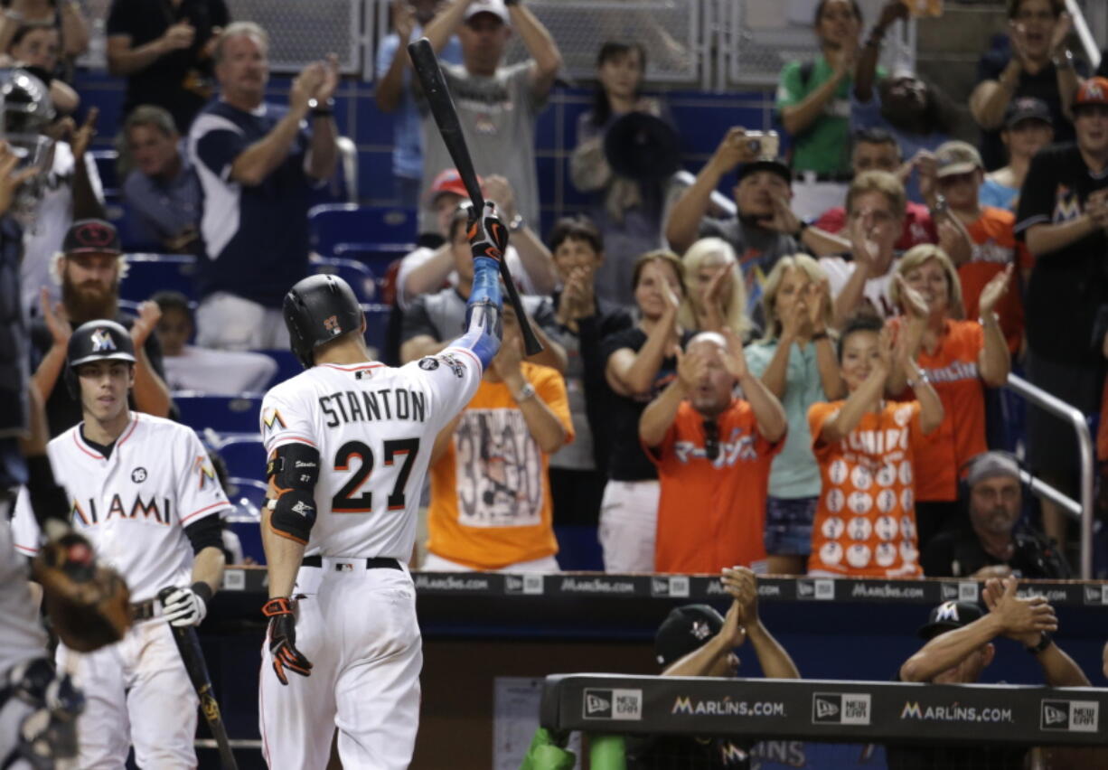 Miami Marlins’ Giancarlo Stanton (27) raises his bat after he struck out swinging for his last at bat during the ninth inning of a baseball game against the Atlanta Braves, Sunday, Oct. 1, 2017, in Miami. The Braves won 8-5. Stanton finished the season with 59 home runs.