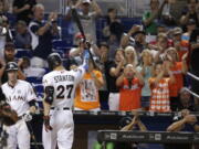 Miami Marlins’ Giancarlo Stanton (27) raises his bat after he struck out swinging for his last at bat during the ninth inning of a baseball game against the Atlanta Braves, Sunday, Oct. 1, 2017, in Miami. The Braves won 8-5. Stanton finished the season with 59 home runs.