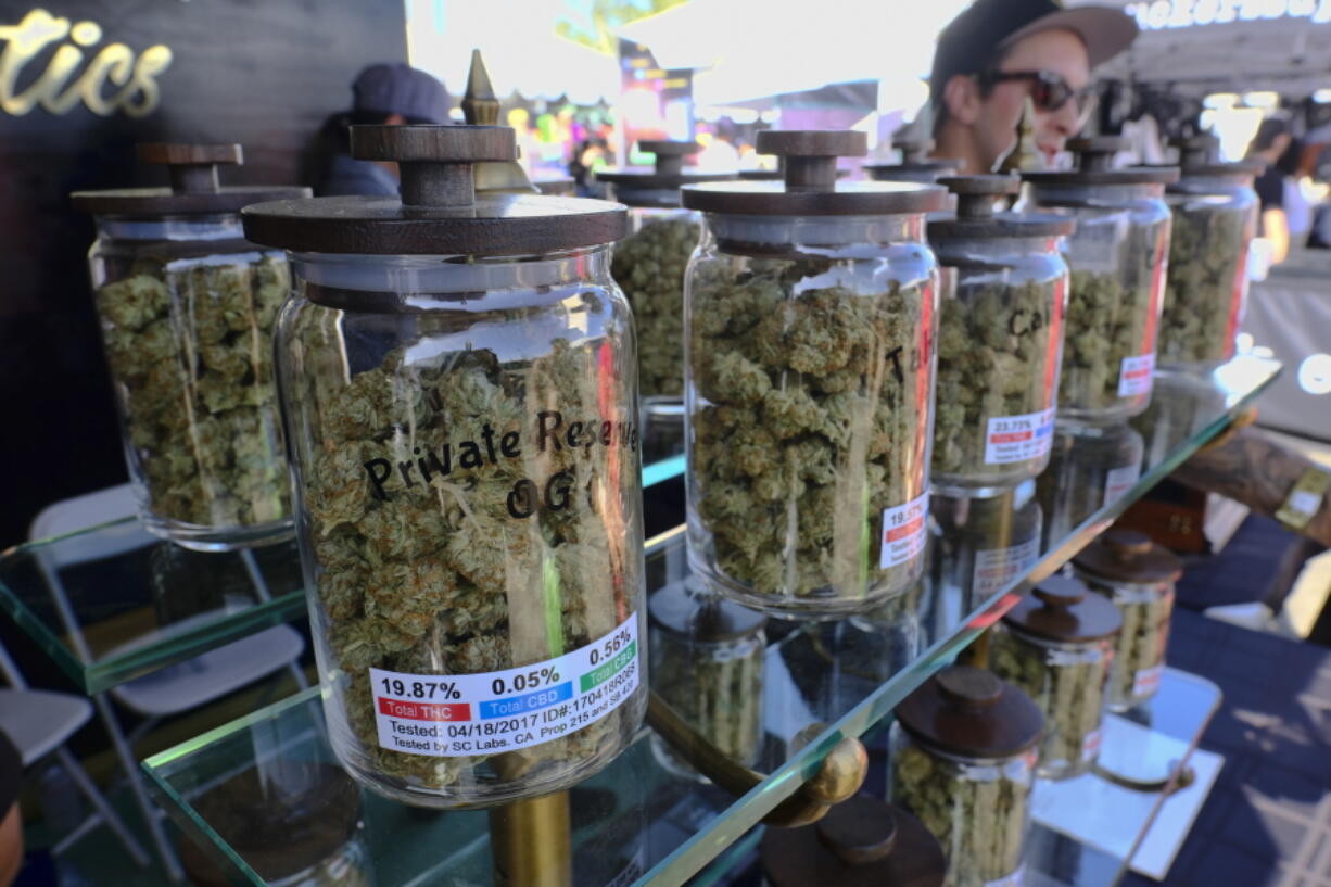 Large jars of marijuana are on display for sale April 23 at the Cali Gold Genetics booth during the High Times Cannabis Cup in San Bernardino, Calif. California is kicking off recreational marijuana sales on Jan. 1, 2018, but there will be plenty of confusion as the new market takes shape. Some places are banning sales, while only a small number appear ready to issue licenses.