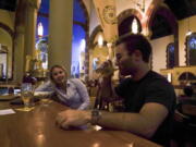 Jesse Hulien, right, drinks a beer as Molly Hartman, left, looks on, at the Church Brew Works, a former church renovated into a brewery, in Pittsburgh. Breweries opening in renovated churches are winning fans but earning disapproval from clergy and worshippers across the U.S.