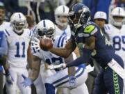 Seattle Seahawks cornerback Justin Coleman, right, intercepts a pass intended for Indianapolis Colts wide receiver Kamar Aiken, center, in the first half of an NFL football game, Sunday, Oct. 1, 2017, in Seattle. Coleman returned the pick for a touchdown.