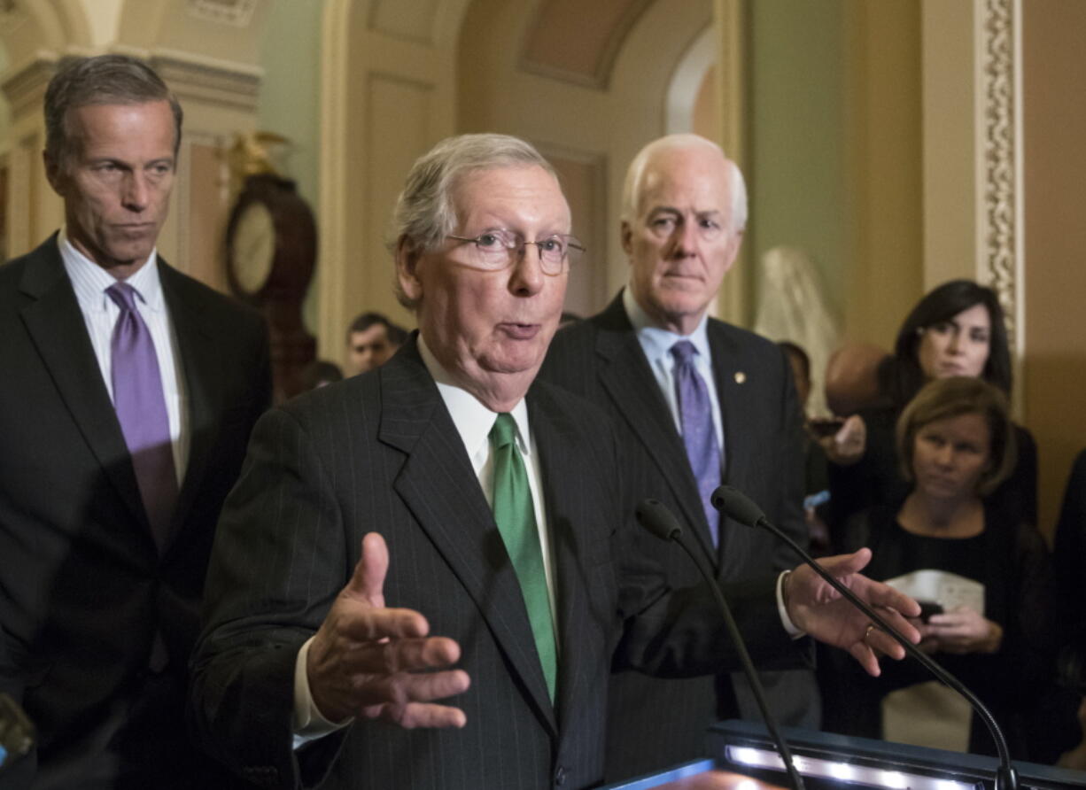 In this Oct. 17, 2017, photo, Senate Majority Leader Mitch McConnell, R-Ky., flanked by Sen. John Thune, R-S.D., left, and Majority Whip John Cornyn, R-Texas, announces to reporters that the Senate is moving ahead on a Republican budget plan at the Capitol in Washington. Senate Republicans seem to be on cruise control to pass a $4 trillion budget plan that shelves GOP deficit concerns in favor of the party’s drive to cut taxes. (AP Photo/J.