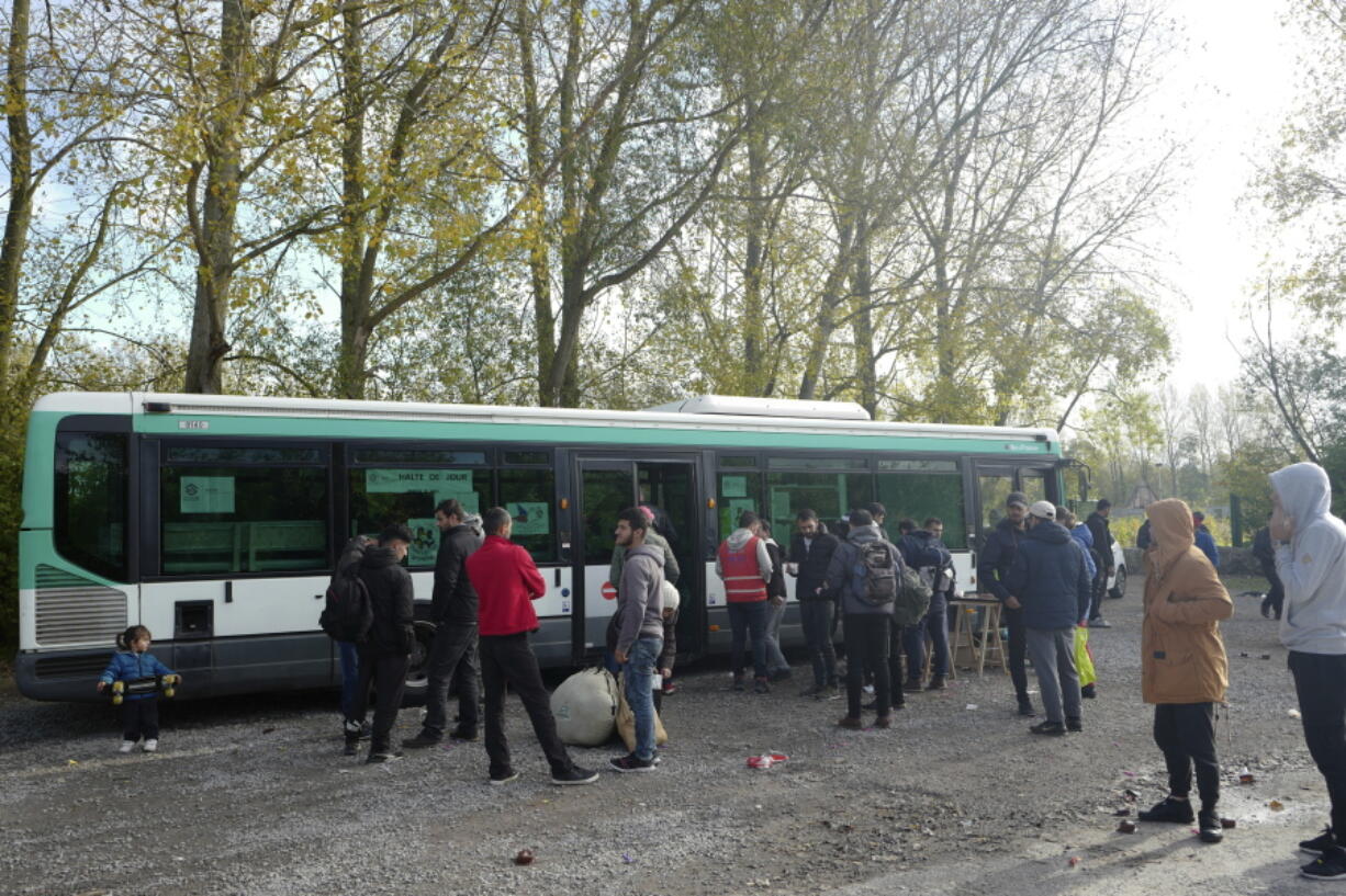 Migrants from Iraqi Kurdistan stand in front of a bus belonging to a charity organization, in Grand-Synthe, near the northern France town of Dunkirk, on Monday. Desperate dreamers keep coming to northern France one year after Europe’s largest slum camp for migrants in Calais went up in flames following a forced evacuation.