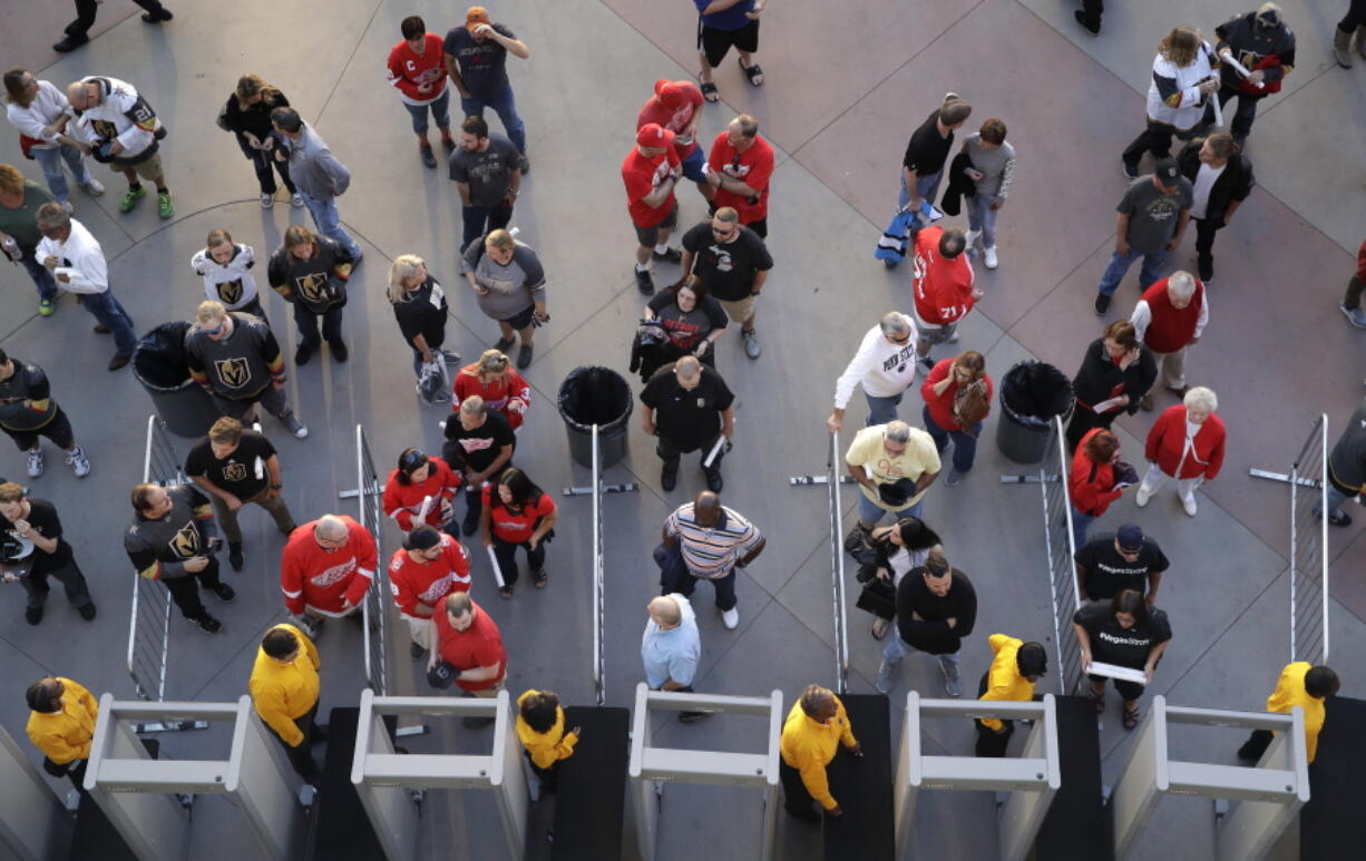 In this Oct. 13, 2017, photo, people wait to go through security at the T-Mobile arena before an NHL hockey game in Las Vegas. The Las Vegas tourism sector is bracing for changes in the aftermath of the massacre that killed 58 people at an outdoor music festival.