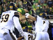 Oregon quarterback Justin Herbert, center, drives into the end zone for a touchdown during the first quarter against California on Saturday. Both quarterback Justin Herbert and running back Royce Freeman were injured in the victory.