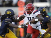 Arizona quarterback Khalil Tate, center, runs for a touchdown past California linebacker Alex Funches, left, during the first half of an NCAA college football game in Berkeley, Calif. Arizona’s quarterback situation was resolved three games ago when Tate took over as starter. Other Pac-12 teams haven’t had the same success in navigating mid-season QB quandaries. Injuries have impacted Oregon and Oregon State at the position.