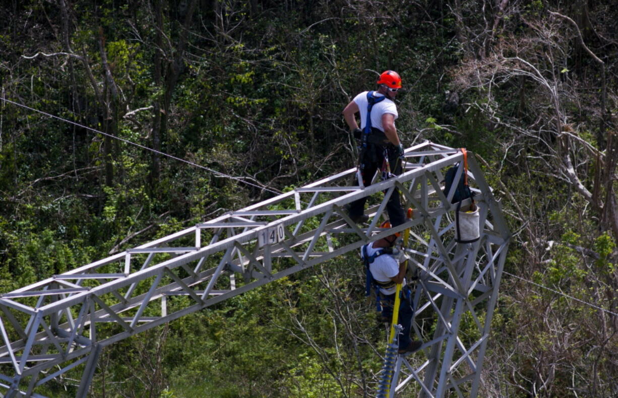 FILE - In this Oct. 15, 2017, file photo, Whitefish Energy Holdings workers restore power lines damaged by Hurricane Maria in Barceloneta, Puerto Rico. The Federal Emergency Management Agency said Oct. 27, it had no involvement in the decision to award a $300 million contract to help restore Puerto Rico’s power grid to a tiny Montana company in Interior Secretary Ryan Zinke’s hometown. FEMA said in a statement that any language in the controversial contract saying the agency approved of the deal with Whitefish Energy Holdings is inaccurate.