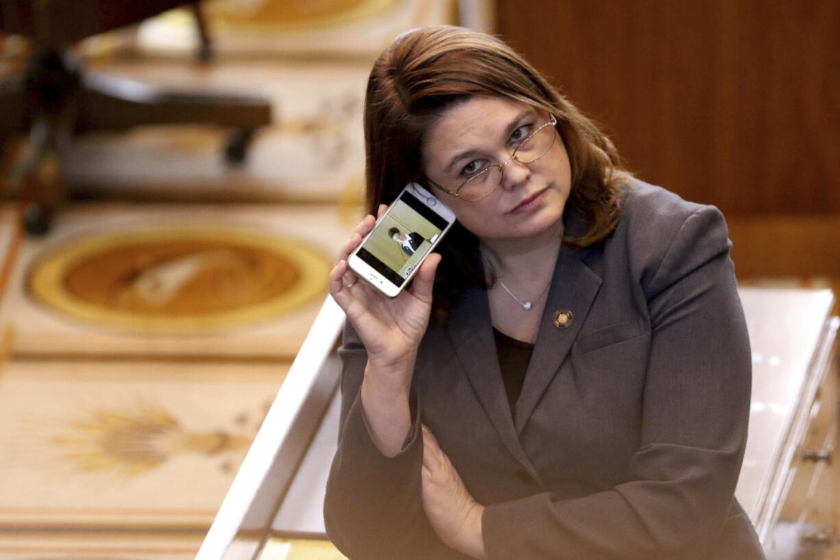 FILE - In this March 3, 2016, file photo, Oregon state Sen. Sara Gelser, D-Corvallis, listens to a live stream as members of the House of Representatives finish business before adjourning the 2016 legislative session at the Oregon State Capitol in Salem, Ore. Democratic Sen. Gelser, who accused Republican Sen. Jeff Kruse of inappropriate touching, said Monday, Oct. 23, 2017, she heard accounts from other women in the Oregon State Capitol of such behavior by men.