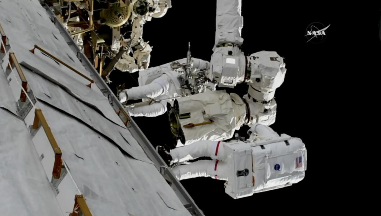 In this frame from NASA TV, Astronauts Mark Vande Hei and Randy Bresnik, bottom, work on the International Space Station on Thursday, Oct. 5, 2017. The astronauts went out on a spacewalk to give the International Space Station’s big robot arm a new hand.