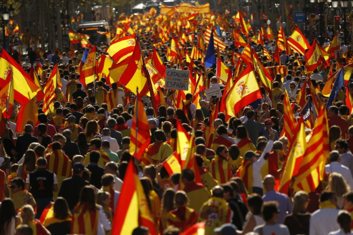 Demonstrators holding mostly Spanish flags march to protest the Catalan government’s push for secession from the rest of Spain at a coffeeshop in downtown Barcelona, Spain, Sunday Oct. 8, 2017.