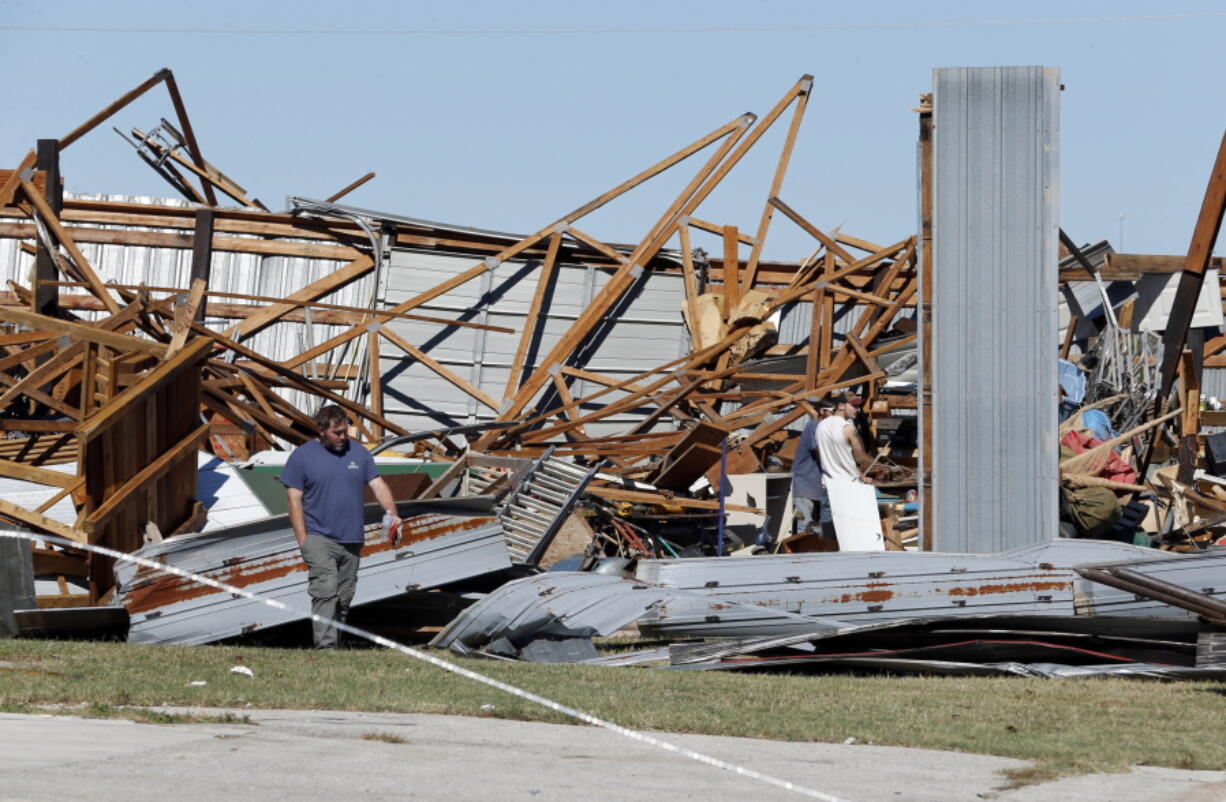 People look at damaged buildings near Norman, Okla., Sunday. Several businesses were hit by an apparent tornado that struck near I35 and Highway 9 on Saturday.