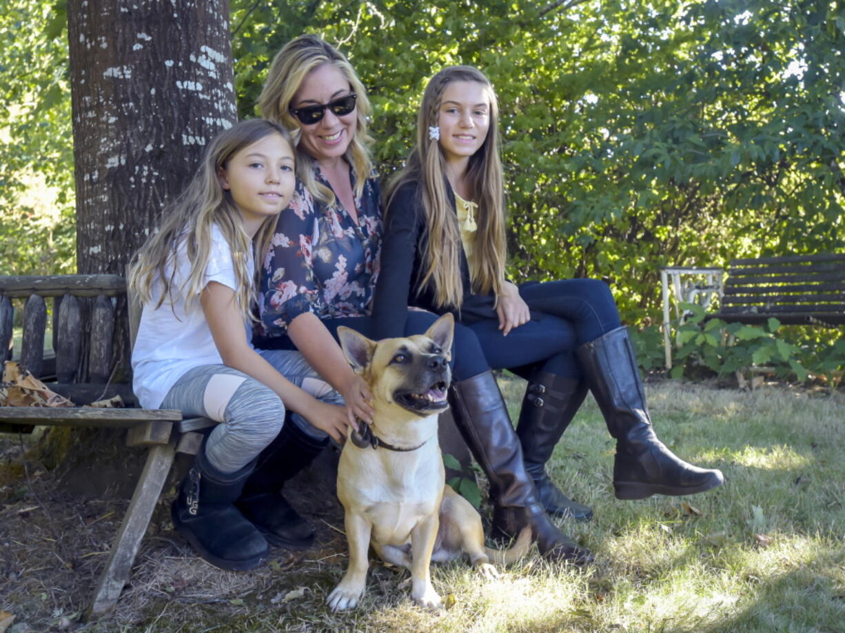 Bakker family members Izzy, 9, from left, Holly and Ally, 11, have been reunited with Gustavo, “Gus” for short, a 4-year-old corgi-German shepherd mix, who is now in Philomath Ore., after surviving Hurricane Maria in Puerto Rico.