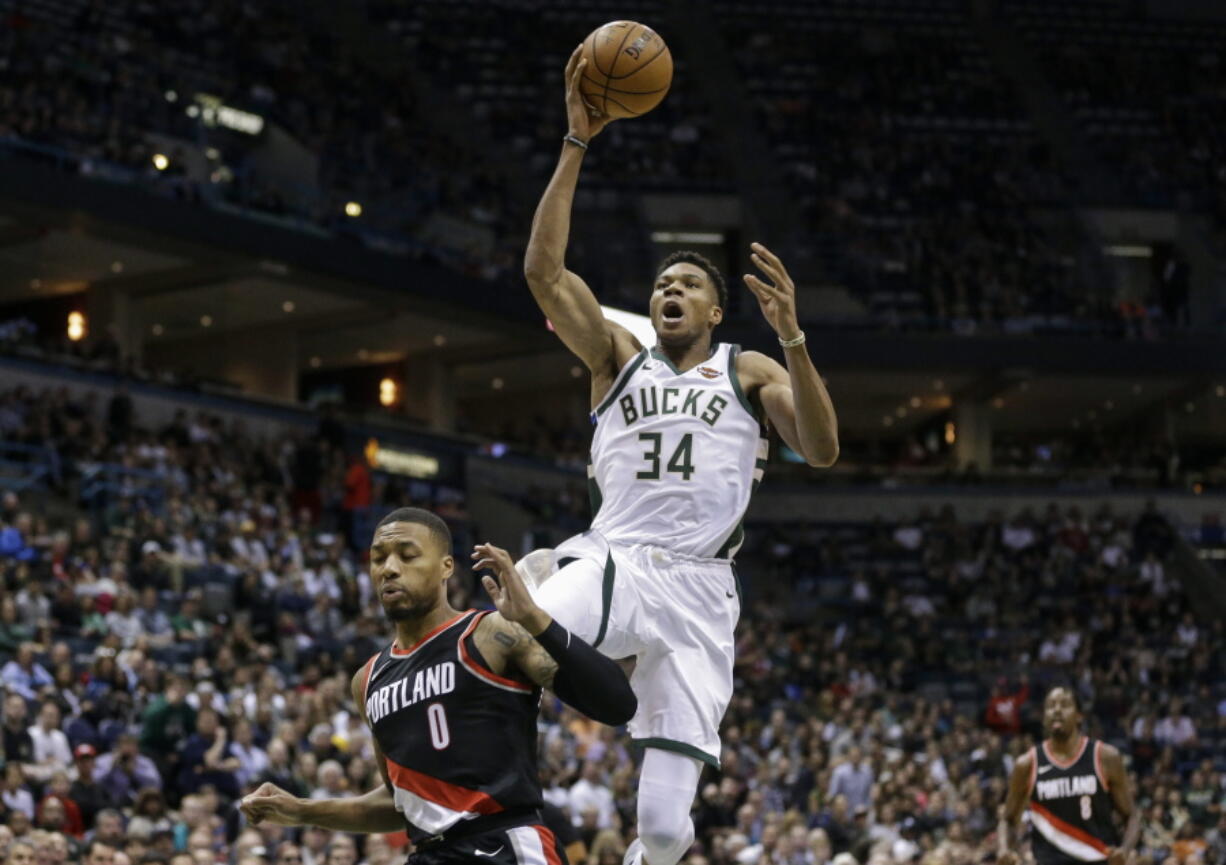 Milwaukee Bucks’ Giannis Antetokounmpo (34) shoots over Portland Trail Blazers’ Damian Lillard during the first half of an NBA basketball game Saturday, Oct. 21, 2017, in Milwaukee.