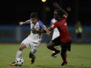 United States’ Christian Pulisic, left, fight for the ball with Trinidad and Tobago’s Nathan Lewis during a 2018 World Cup qualifying soccer match in Couva, Trinidad, Tuesday, Oct. 10, 2017.