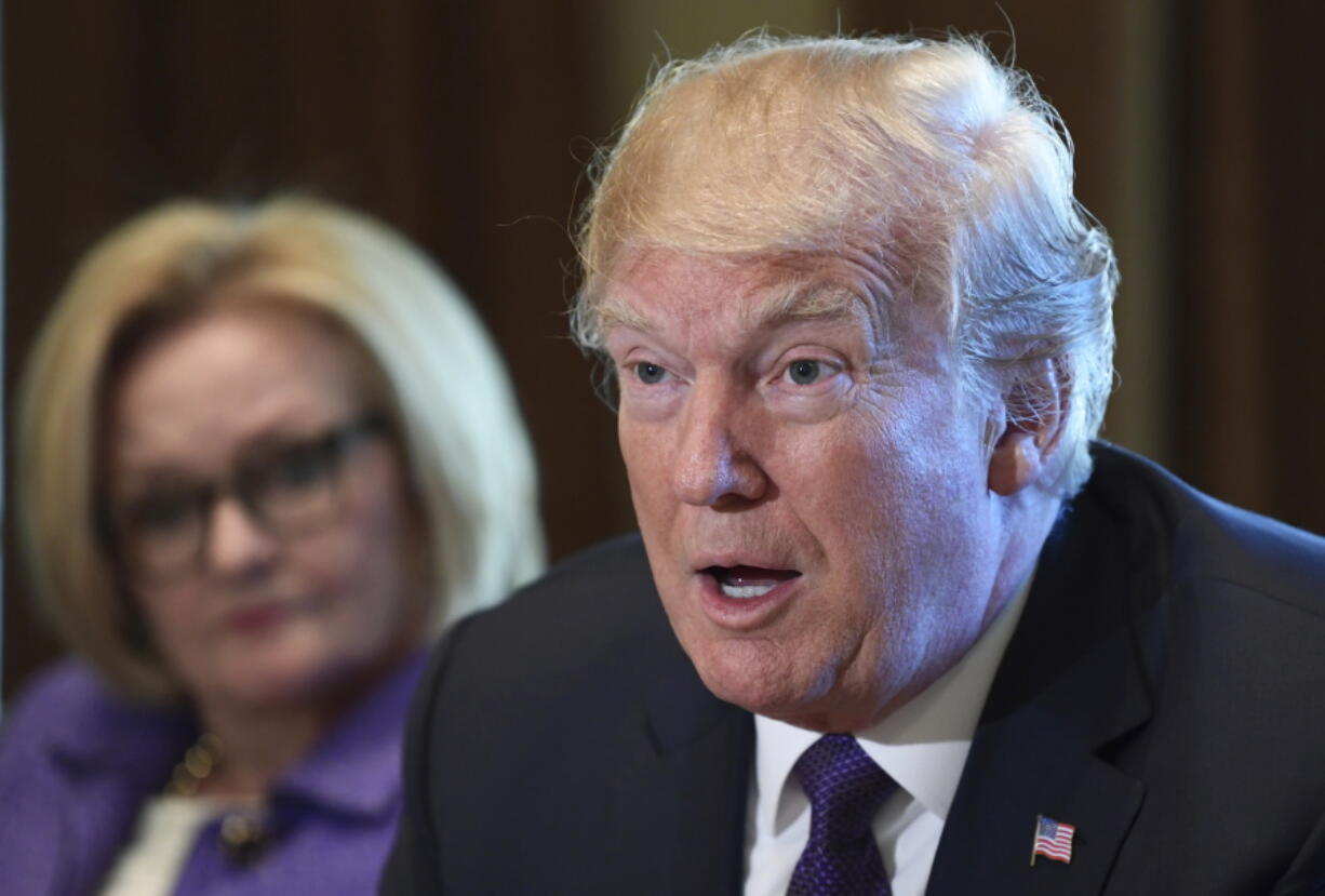 President Donald Trump, right, sitting next to Sen. Claire McCaskill, D-Mo., left, speaks during a meeting with members of the Senate Finance Committee and members of the President’s economic team in the Cabinet Room of the White House in Washington on Wednesday.