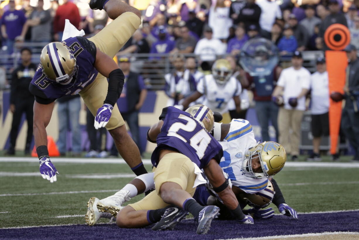 UCLA’s Jordan Wilson, right scores against Washington in the first half of an NCAA college football game Saturday, Oct. 28, 2017, in Seattle.