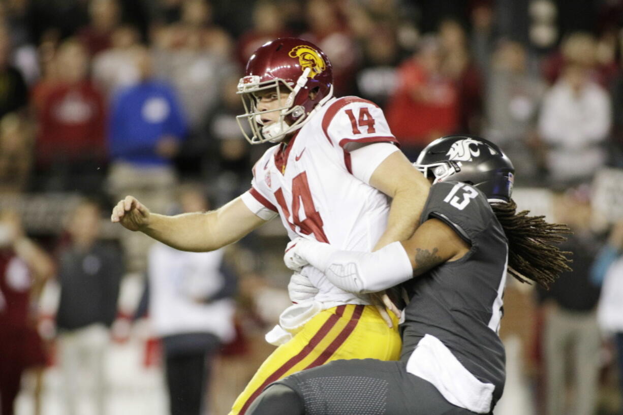 Washington State linebacker Jahad Woods (13) tackles Southern California quarterback Sam Darnold (14) after Darnold fumbles the ball during the second half Friday in Pullman. Washington State won 30-27. Darnold, a Heisman contender, was held to 164 yards passing.