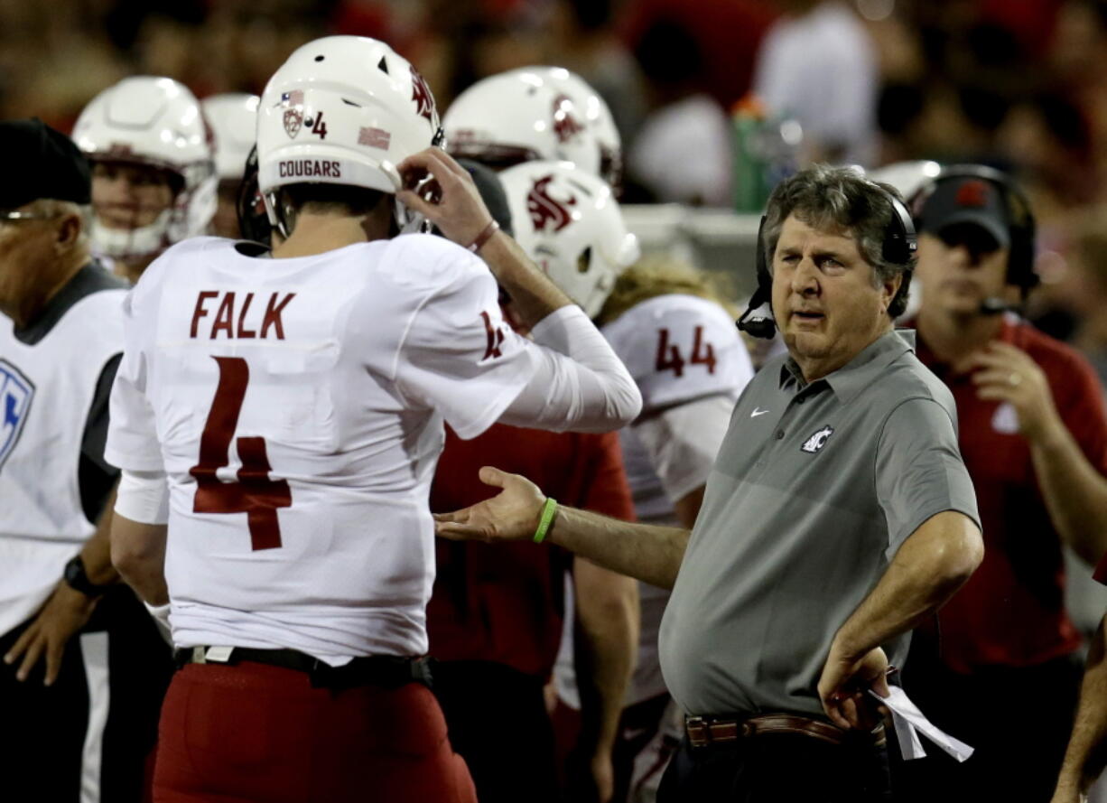 Washington State head coach Mike Leach, right, talks to quarterback Luke Falk in the first half during an NCAA college football game against Arizona, Saturday, Oct. 28, 2017, in Tucson, Ariz.