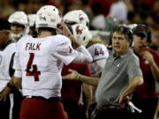 Washington State head coach Mike Leach, right, talks to quarterback Luke Falk in the first half during an NCAA college football game against Arizona, Saturday, Oct. 28, 2017, in Tucson, Ariz.