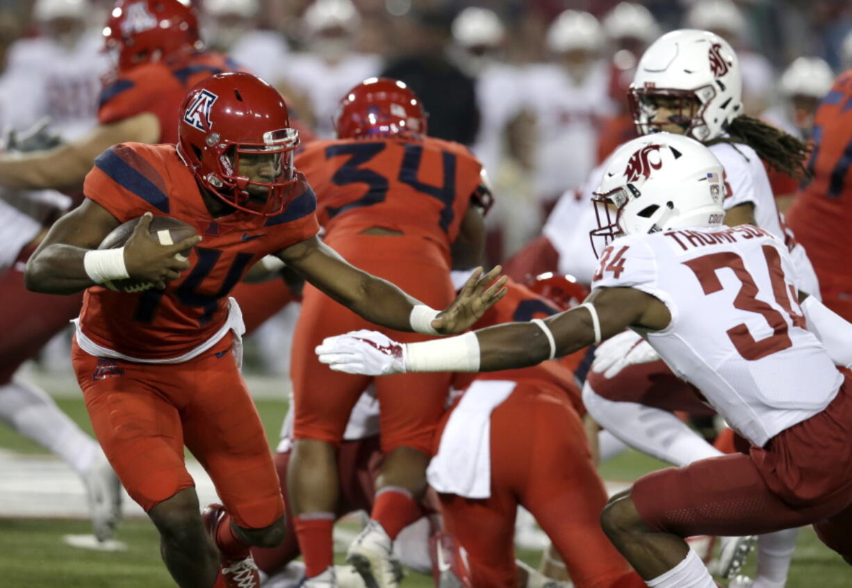 Arizona quarterback Khalil Tate (14) stiff-arms Washington State safety Jalen Thompson (34) in the first half during an NCAA college football game, Saturday, Oct. 28, 2017, in Tucson, Ariz.