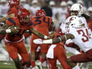 Arizona quarterback Khalil Tate (14) stiff-arms Washington State safety Jalen Thompson (34) in the first half during an NCAA college football game, Saturday, Oct. 28, 2017, in Tucson, Ariz.