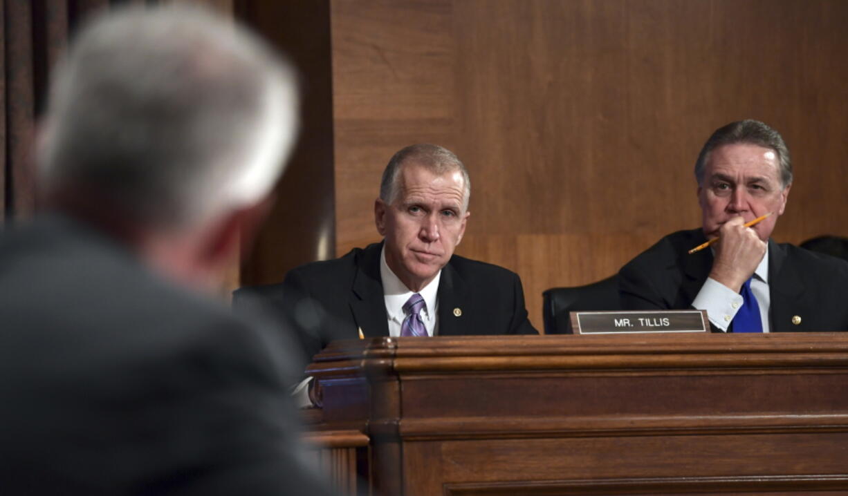 Sen. Thom Tillis, R-N.C.,, center, and Sen. David Perdue, R-Ga., right, listen as Wells Fargo Chief Executive Officer and President Timothy Sloan testifies before the Senate Committee on Banking, Housing and Urban Affairs on Capitol Hill in Washington, Tuesday, Oct. 3, 2017.