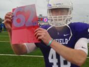 Linfield kicker Willy Warne holds a sign signifying the football program's 62nd consecutive winning season. Warne, a Mountain View High grad, made four field goals in a 12-6 win over George Fox on Saturday, Oct. 21.