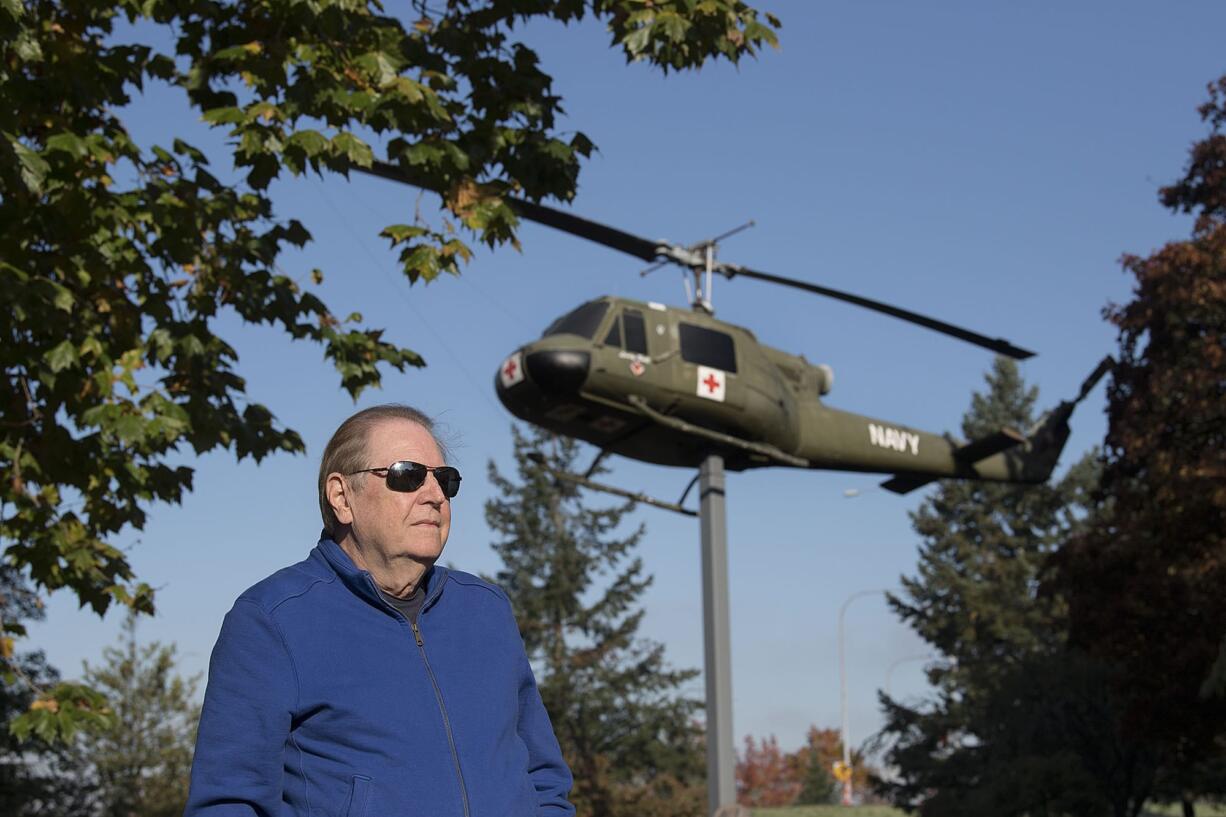 Vietnam War veteran Jim Voorhees pauses for a portrait with a Vietnam-era Huey helicopter named "Lady Bell" at the Vietnam War Memorial on Oct. 25. Voorhees flew two tours as an Army helicopter pilot.