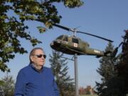 Vietnam War veteran Jim Voorhees pauses for a portrait with a Vietnam-era Huey helicopter named "Lady Bell" at the Vietnam War Memorial on Oct. 25. Voorhees flew two tours as an Army helicopter pilot.